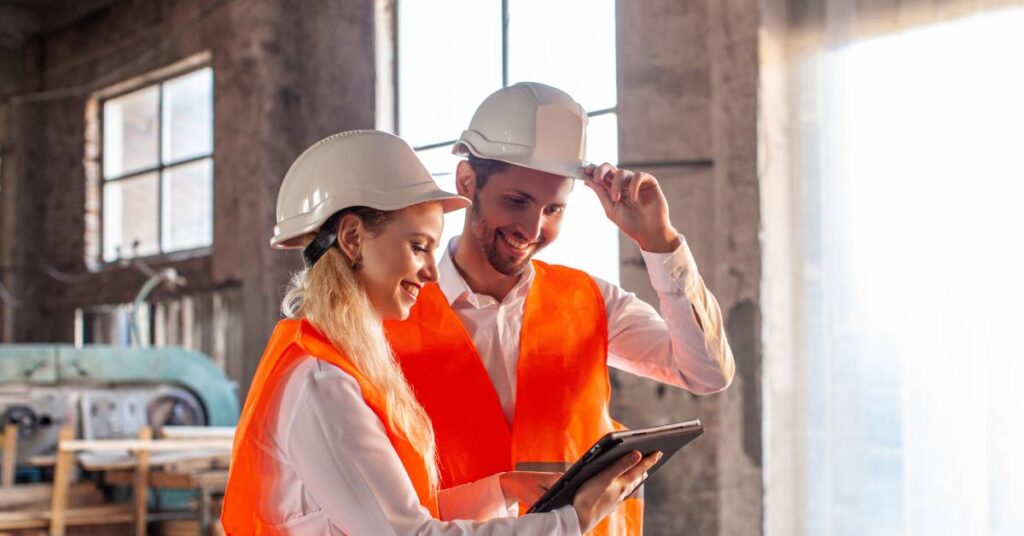 Construction professionals discussing plans on-site, symbolising recruitment and teamwork.